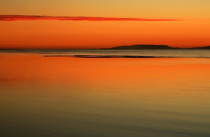 Sunset over the sea with distant island