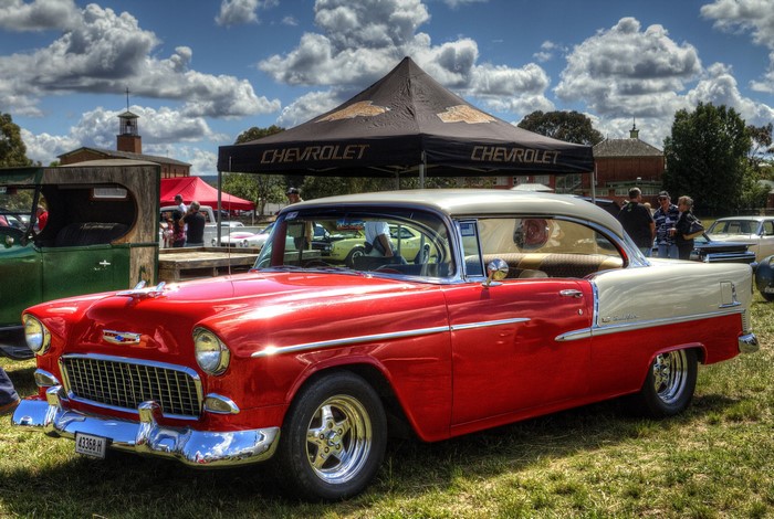 Red and white Chevrolet classic car at an outdoor event