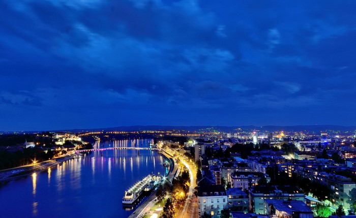 Novi Sad cityscape at night with river and bridge
