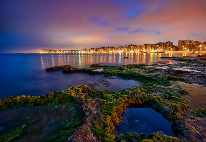 Torrevieja coast at night with city lights reflecting on the water