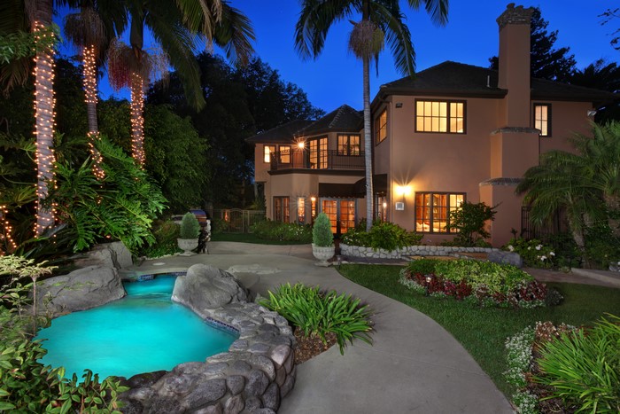 Luxury Mansion with Pool and Palm Trees at Night