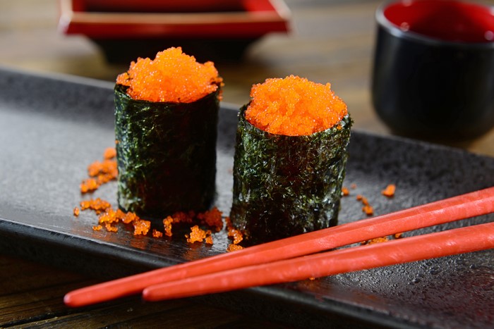 Sushi with orange caviar and chopsticks