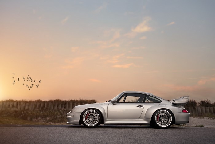 Silver Porsche 911 GT2 on a road at sunset