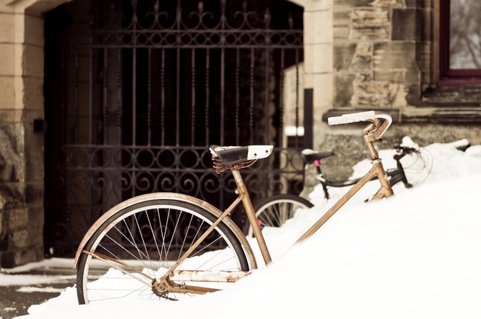 Bicycles covered in snow near a building