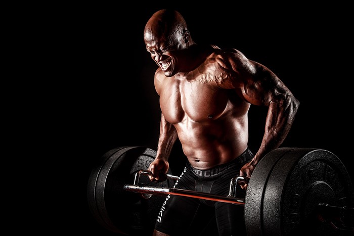 Bodybuilder performing deadlifts with a barbell
