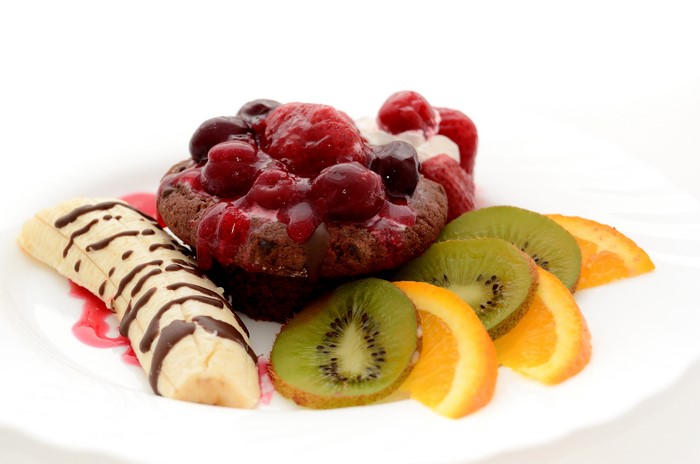 Chocolate pastry with berries, banana, kiwi, and orange slices