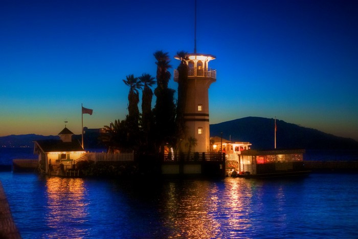 Lighthouse and buildings on the water at dusk