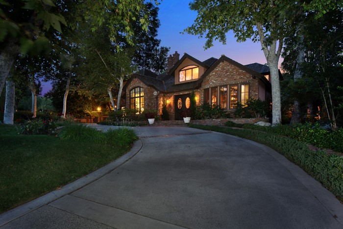 Brick house with arched windows and double doors at night