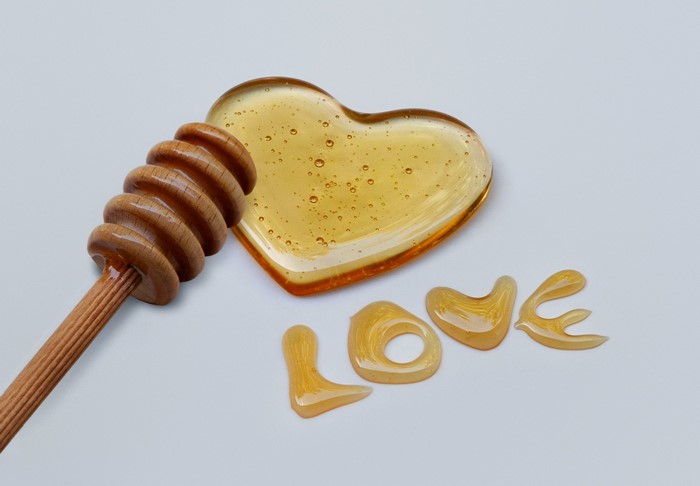 Honey heart and wooden dipper with word LOVE