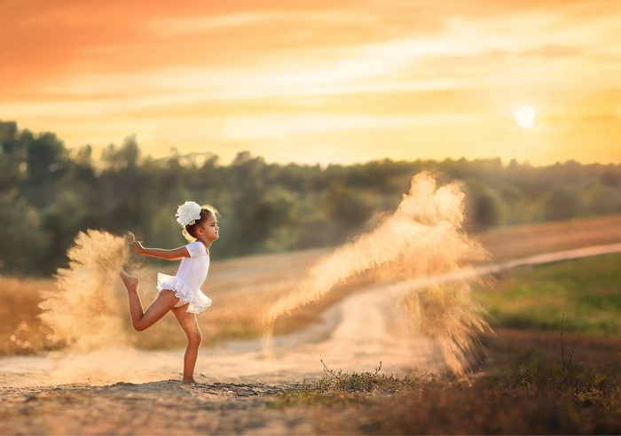 Girl dancing with dust at sunset