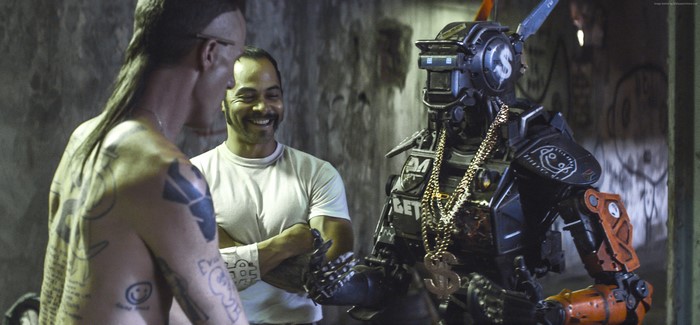 Chappie with two men in a gritty environment