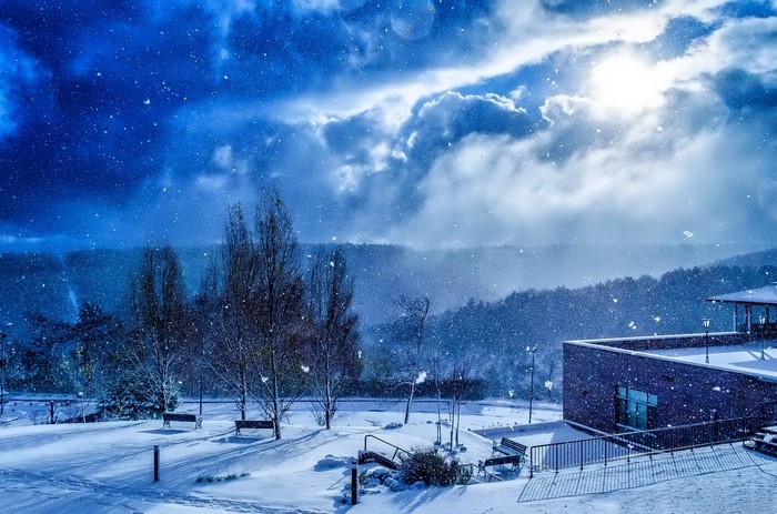 Winter scene with snow falling and a building