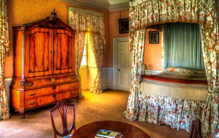 Bedroom with antique furniture and floral curtains