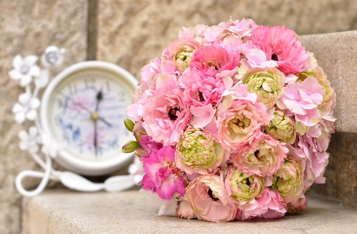 Pink and green floral bouquet with decorative clock