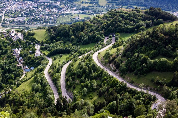 Winding mountain road in France with a village below
