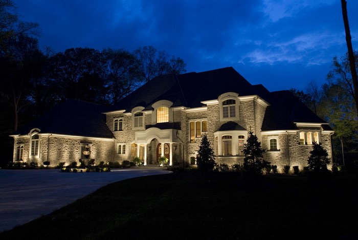 Large stone mansion illuminated at night
