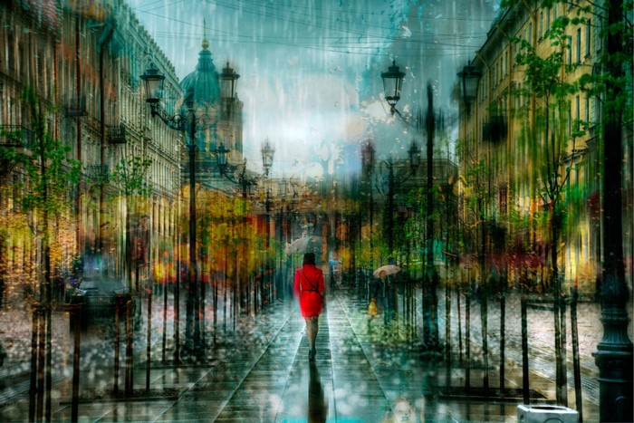 Woman in red coat walking on rainy St. Petersburg street