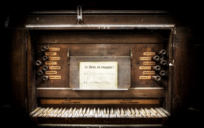 Close-up of an old pipe organ keyboard and sheet music