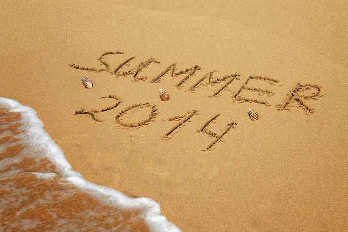Summer 2014 written in sand on a beach