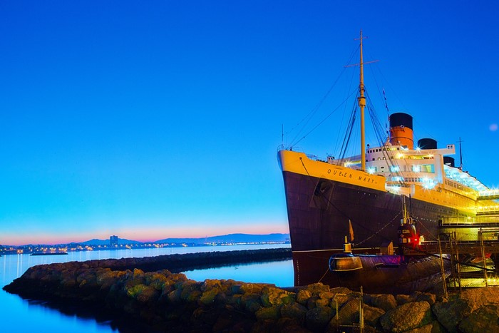 The Queen Mary ship docked at night with a submarine