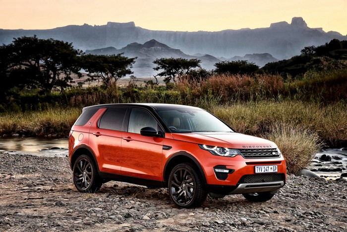 Orange Land Rover Discovery Sport in a rocky landscape