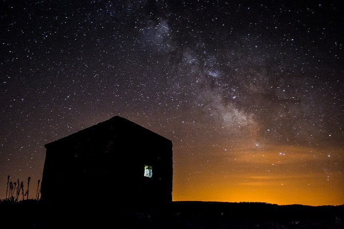 Silhouette of a building under the Milky Way