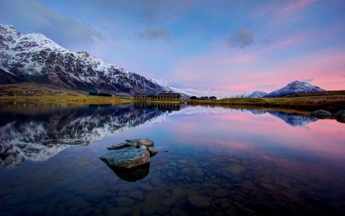 Lake with snow-capped mountains at sunset