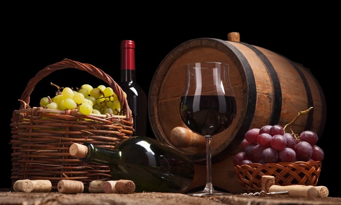 Wine bottle, grapes, glass, and barrel