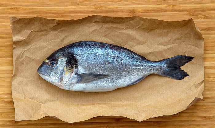 Whole raw fish on brown paper