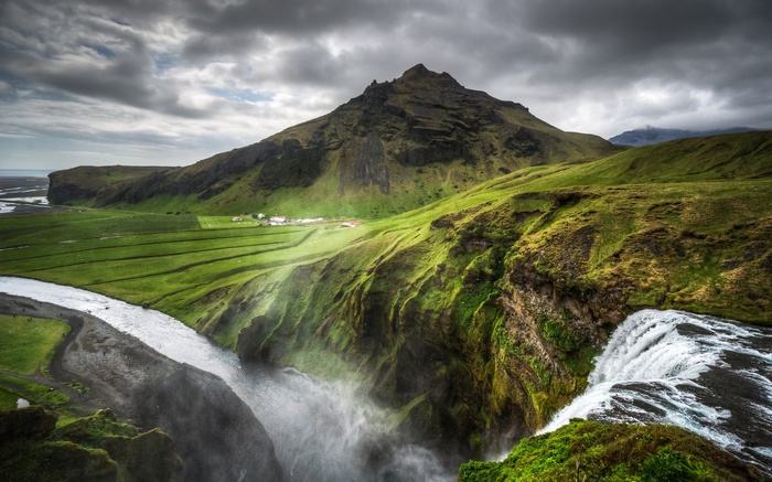 Waterfall cascading over green cliffs in Iceland