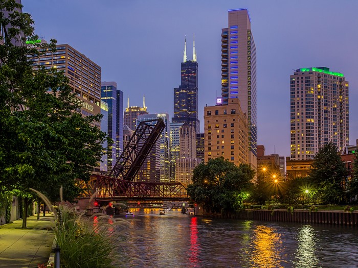 Chicago River with drawbridge and skyscrapers at dusk