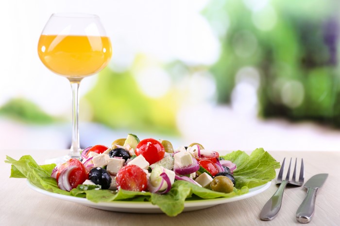 Greek salad with orange juice in a wine glass