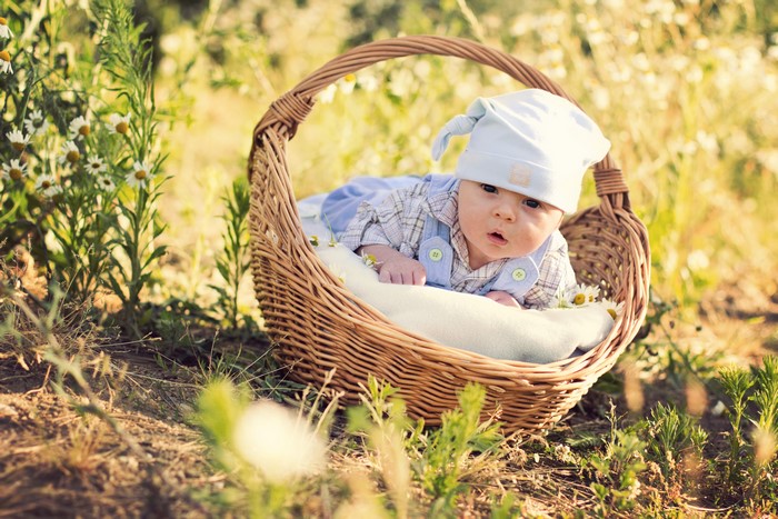 Infant in a wicker basket outdoors