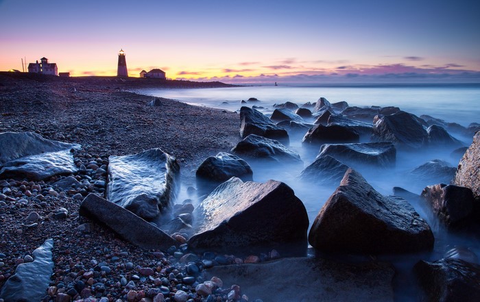 4K Lighthouse on Rocky Shore at Dusk