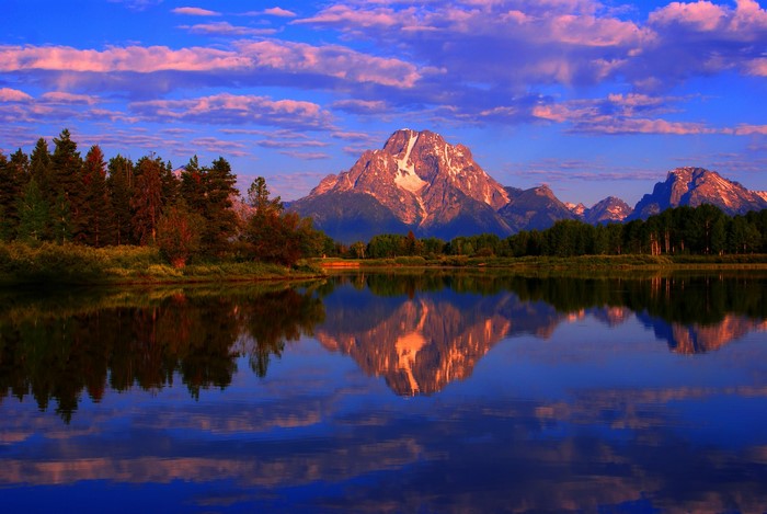 Grand Teton Mountains reflected in a lake at sunrise