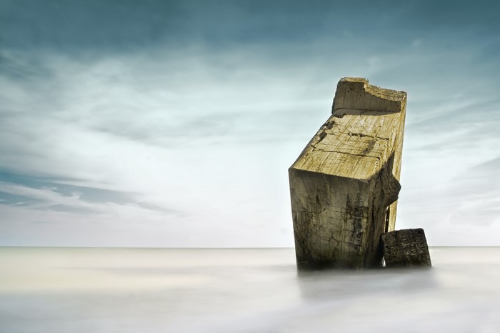 Concrete structure in the sea under a cloudy sky