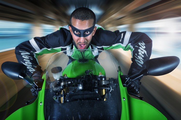 Man in Ninja mask riding a Kawasaki motorcycle