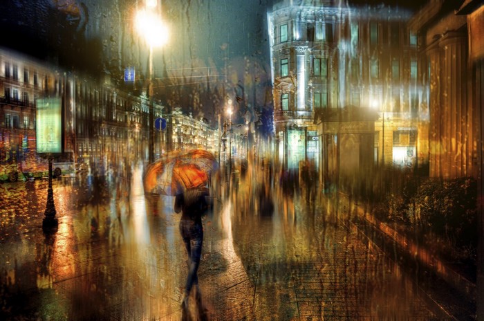 Woman with umbrella on a rainy St. Petersburg street at night