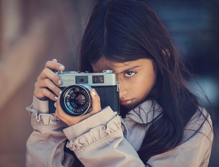 Girl holding a Konica camera