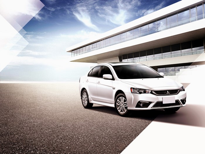 White Mitsubishi Lancer Fortis TW-spec parked in front of modern building