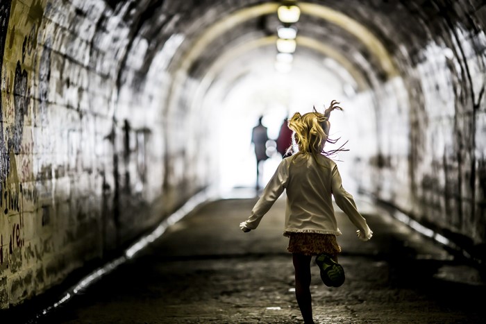 Little girl running in a tunnel