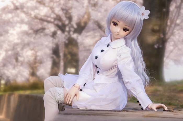 Doll in a white dress with cherry blossoms