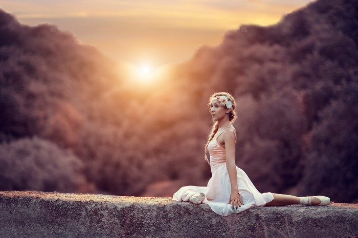 Ballerina in a field at sunset