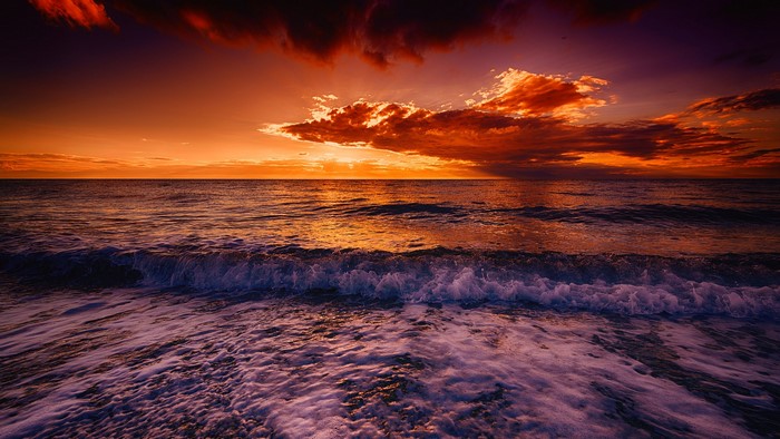 Ocean waves at sunset with dramatic clouds