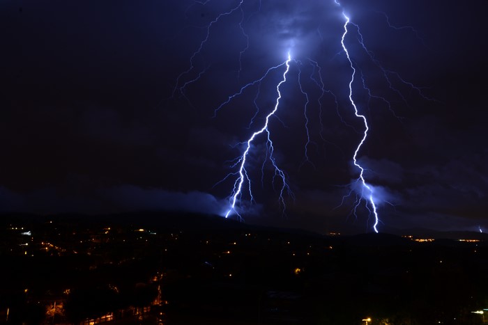 Lightning strikes over a city at night