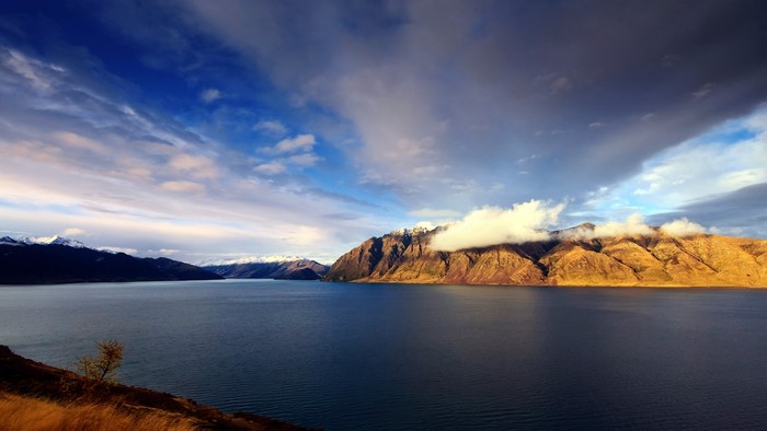Lake and mountains under a cloudy sky