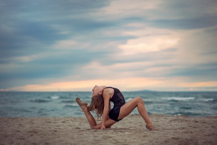 Girl doing gymnastics on the beach