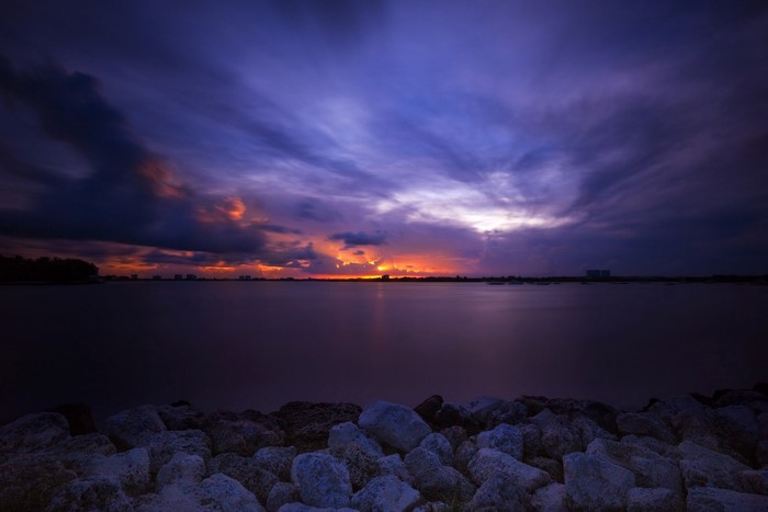 Sunset over the sea with rocks in the foreground