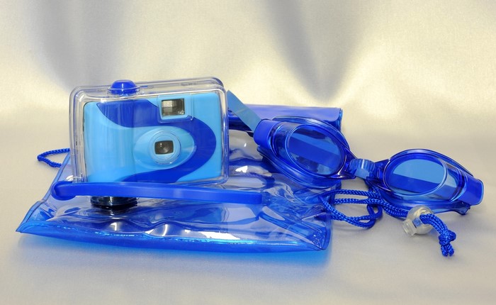 Blue waterproof camera and goggles on a bag