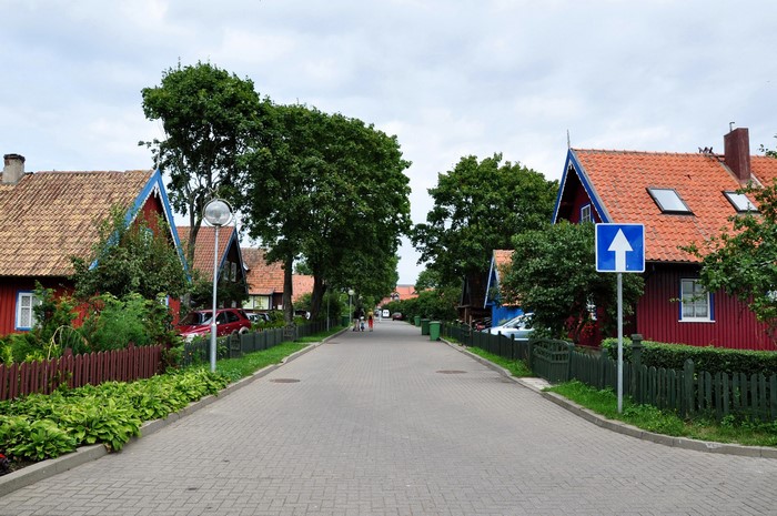 Street with colorful houses and trees in Nida, Lithuania